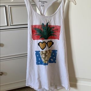 A girls white tank with pineapple on the front